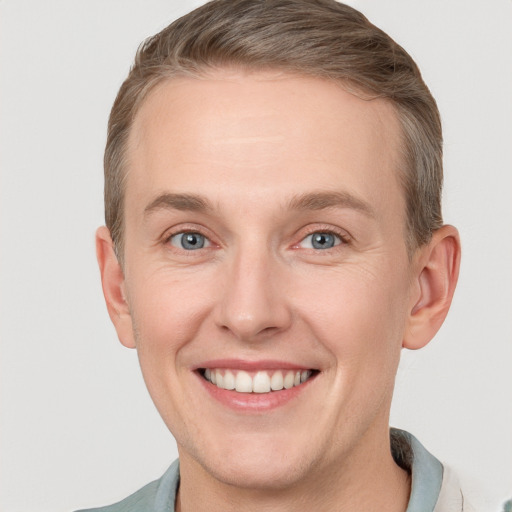 Joyful white young-adult male with short  brown hair and blue eyes