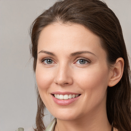 Joyful white young-adult female with medium  brown hair and grey eyes