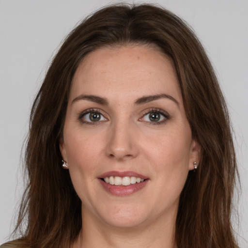 Joyful white young-adult female with long  brown hair and brown eyes