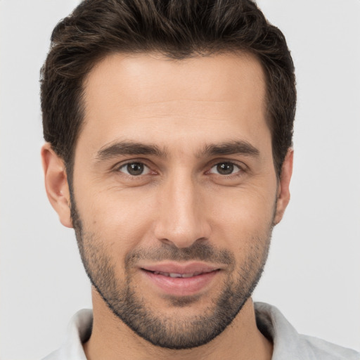 Joyful white young-adult male with short  brown hair and brown eyes