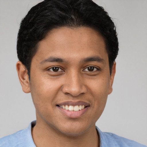 Joyful latino young-adult male with short  brown hair and brown eyes