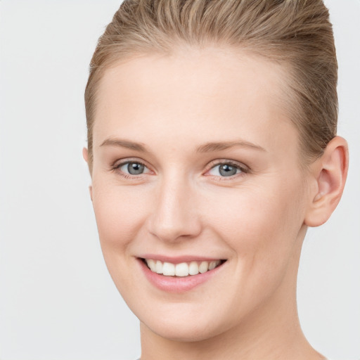 Joyful white young-adult female with short  brown hair and grey eyes