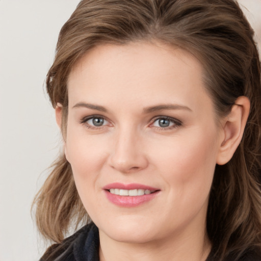 Joyful white young-adult female with long  brown hair and grey eyes