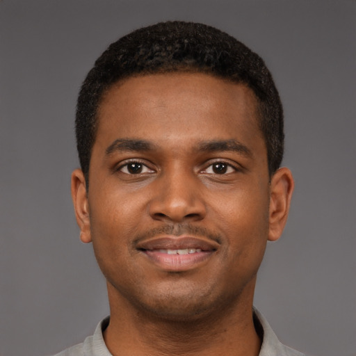 Joyful black young-adult male with short  brown hair and brown eyes