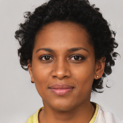 Joyful black young-adult female with short  black hair and brown eyes