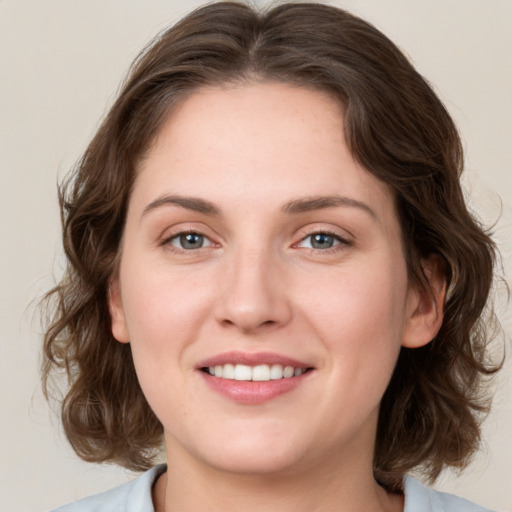 Joyful white young-adult female with medium  brown hair and green eyes