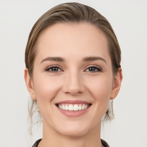 Joyful white young-adult female with medium  brown hair and grey eyes