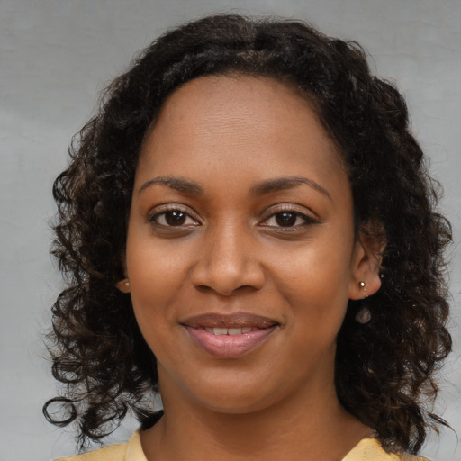 Joyful black young-adult female with medium  brown hair and brown eyes