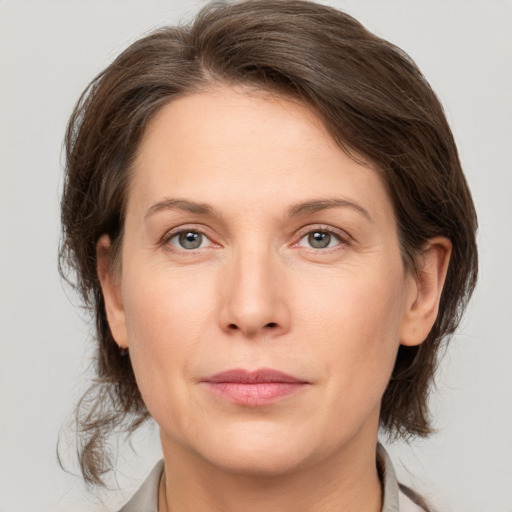 Joyful white adult female with medium  brown hair and grey eyes