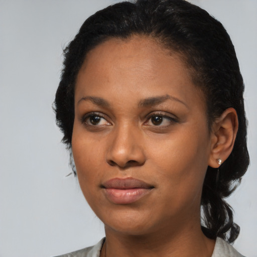 Joyful black young-adult female with medium  black hair and brown eyes