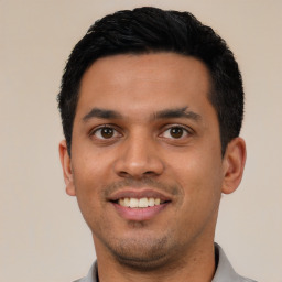 Joyful latino young-adult male with short  black hair and brown eyes