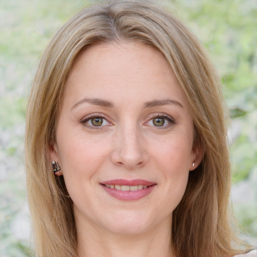 Joyful white adult female with long  brown hair and green eyes