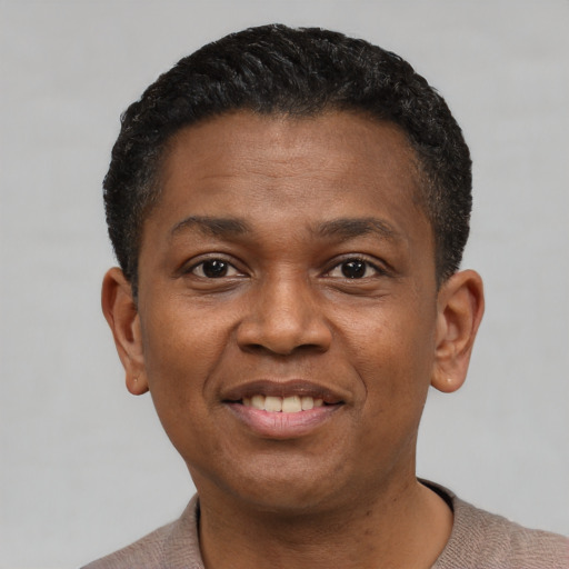Joyful black young-adult male with short  black hair and brown eyes