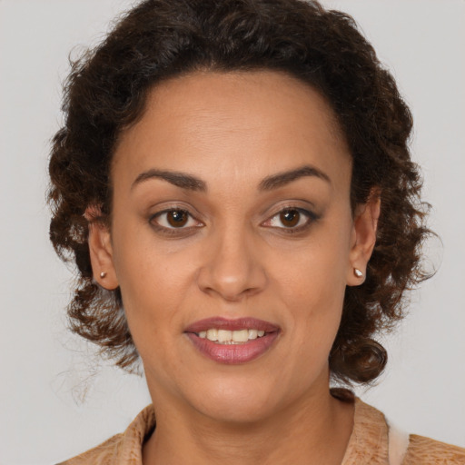 Joyful black adult female with medium  brown hair and brown eyes