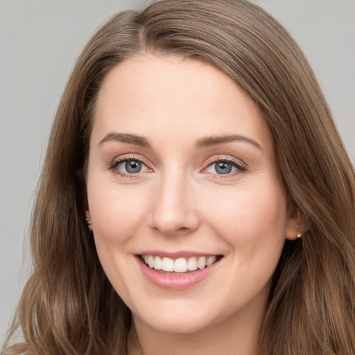 Joyful white young-adult female with long  brown hair and grey eyes