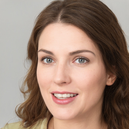 Joyful white young-adult female with medium  brown hair and green eyes