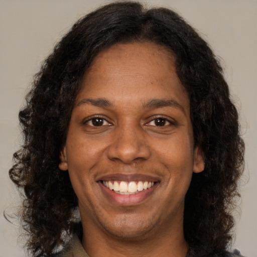 Joyful black young-adult female with medium  brown hair and brown eyes