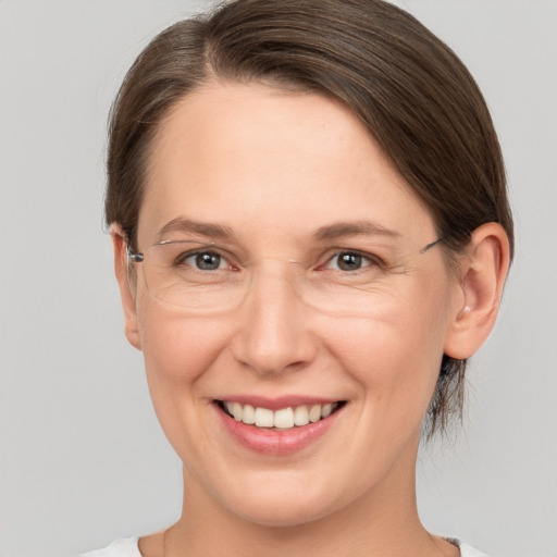 Joyful white adult female with medium  brown hair and grey eyes