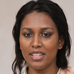 Joyful black young-adult female with long  brown hair and brown eyes