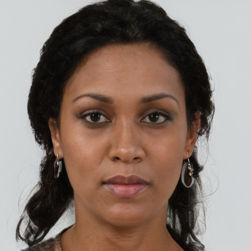 Joyful latino adult female with medium  brown hair and brown eyes