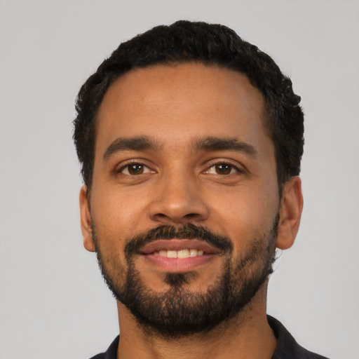 Joyful latino young-adult male with short  black hair and brown eyes