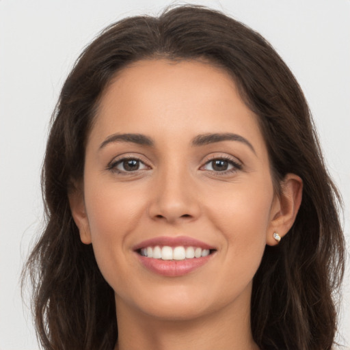 Joyful white young-adult female with long  brown hair and brown eyes