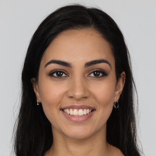 Joyful latino young-adult female with long  brown hair and brown eyes