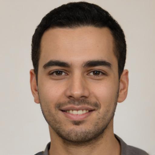 Joyful white young-adult male with short  black hair and brown eyes