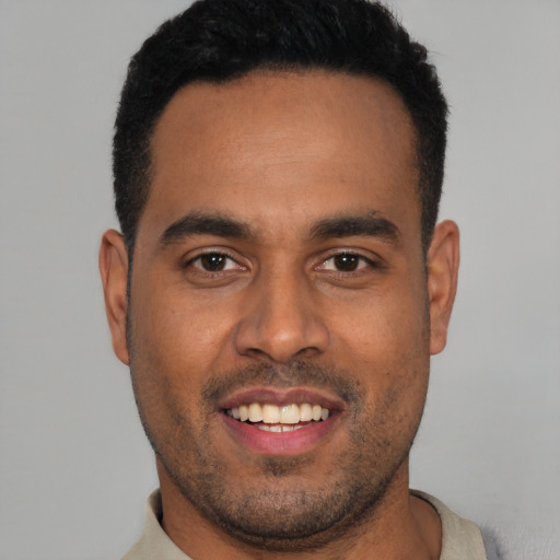 Joyful latino young-adult male with short  black hair and brown eyes