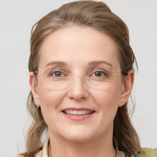 Joyful white adult female with medium  brown hair and grey eyes