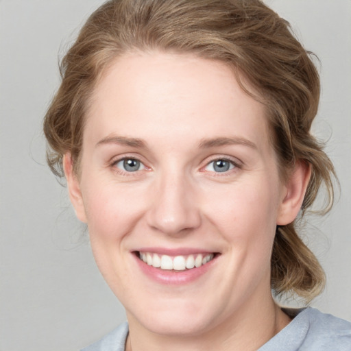 Joyful white young-adult female with medium  brown hair and blue eyes