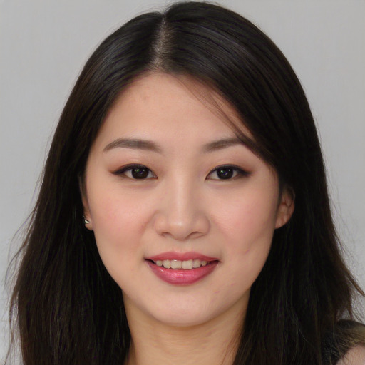 Joyful asian young-adult female with long  brown hair and brown eyes