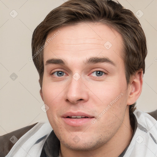 Joyful white young-adult male with short  brown hair and grey eyes