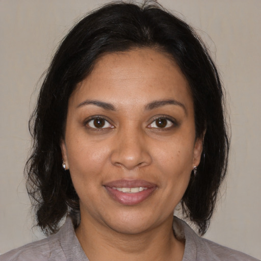 Joyful black adult female with medium  brown hair and brown eyes