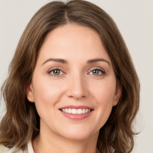 Joyful white young-adult female with medium  brown hair and green eyes