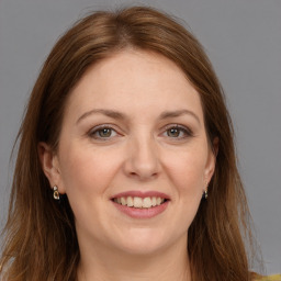 Joyful white adult female with long  brown hair and grey eyes