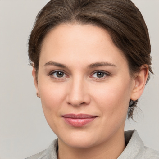 Joyful white young-adult female with medium  brown hair and grey eyes