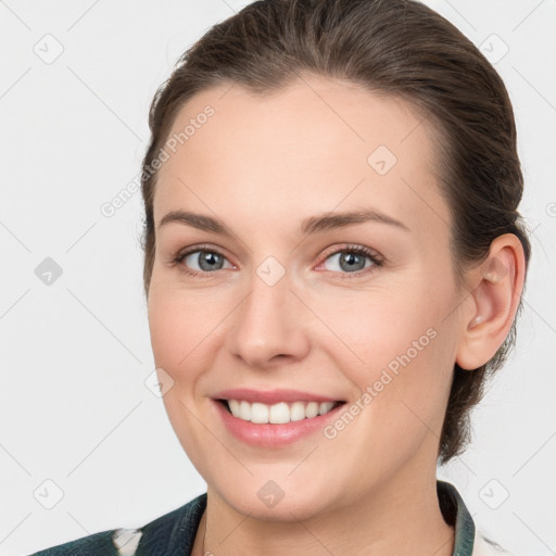 Joyful white young-adult female with medium  brown hair and grey eyes