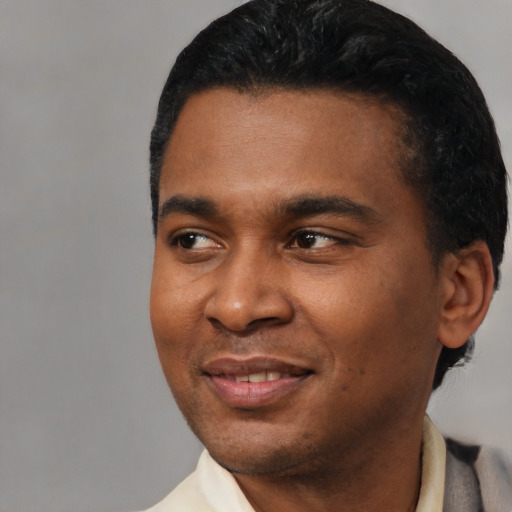 Joyful latino young-adult male with short  black hair and brown eyes