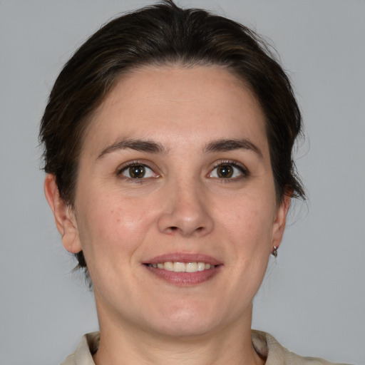 Joyful white young-adult female with medium  brown hair and grey eyes