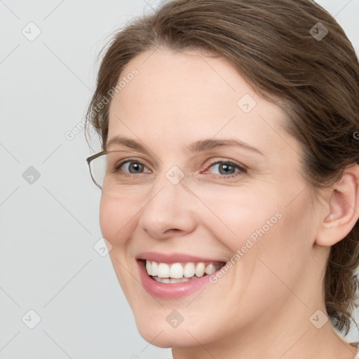 Joyful white young-adult female with medium  brown hair and grey eyes