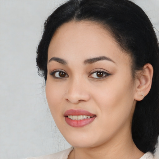 Joyful latino young-adult female with long  black hair and brown eyes