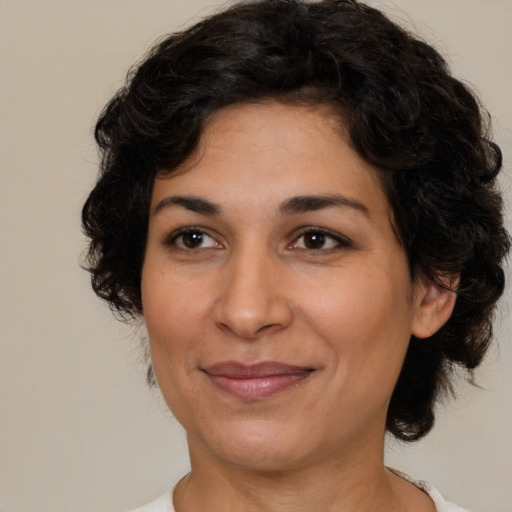 Joyful latino adult female with medium  brown hair and brown eyes