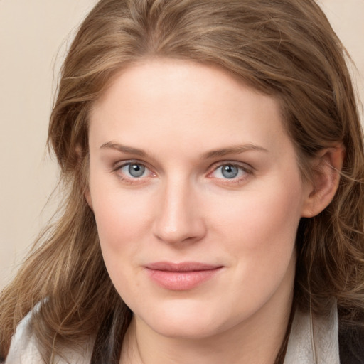 Joyful white young-adult female with long  brown hair and blue eyes