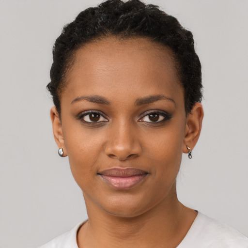 Joyful black young-adult female with short  black hair and brown eyes