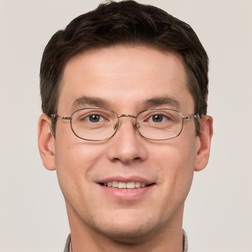 Joyful white young-adult male with short  brown hair and grey eyes