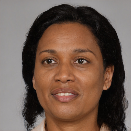 Joyful black adult female with medium  brown hair and brown eyes