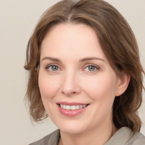 Joyful white young-adult female with medium  brown hair and grey eyes