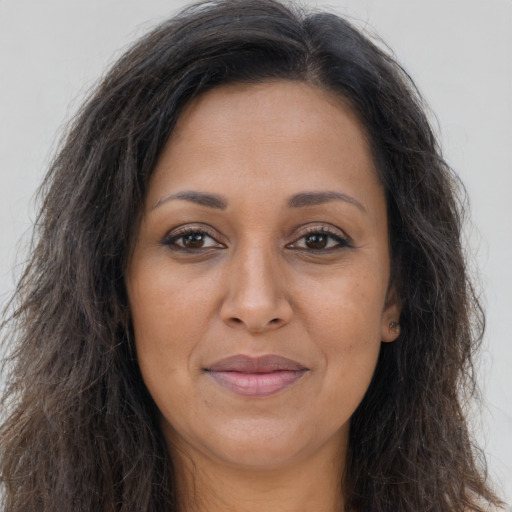 Joyful latino adult female with long  brown hair and brown eyes