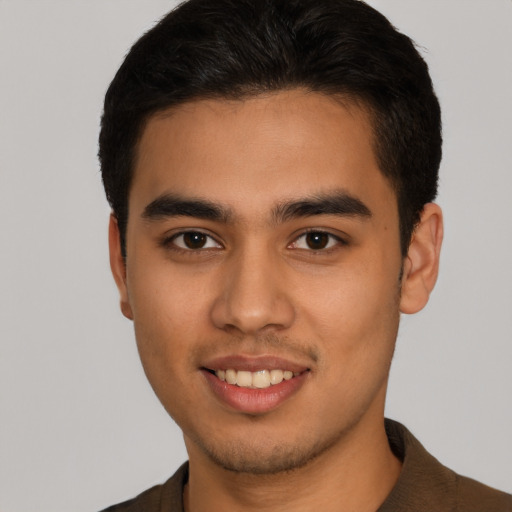 Joyful latino young-adult male with short  brown hair and brown eyes
